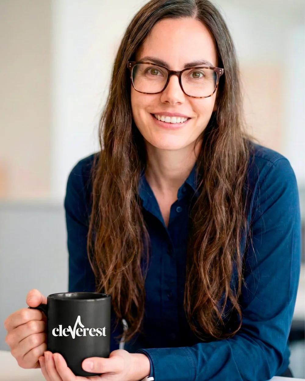 Louise, founder of Cleverest, holding a Cleverest mug